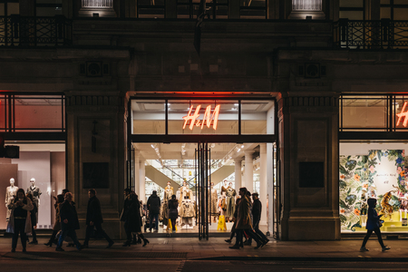 London, UK - March 6, 2019: People walking in front of H&M store on Regent Street, London, in the evening. Regent Street is one of the most famous shopping streets in the London.のeditorial素材