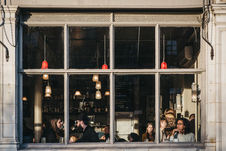 London, UK - February 03, 2019: View through the window of people inside Market Cafe pub on Broadway Market, a shopping street in the heart of Hackney, East London, UK.のeditorial素材