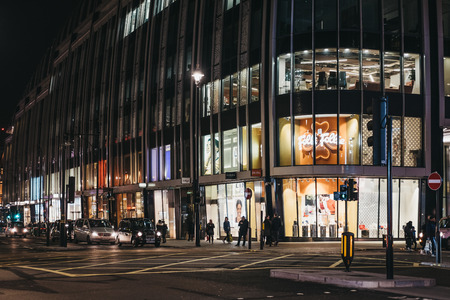 London, UK - March 9, 2019: People walking in front of shops on Oxford Street, London, in the evening. Oxford street is one of the most famous shopping streets in London.のeditorial素材