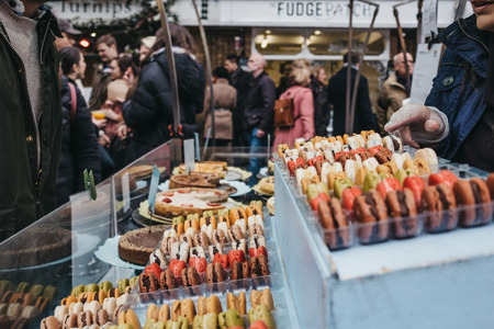 London, UK - March 16. 2019: People buying colorful macaroons from a market stall at Greenwich Market, London's only market set within a World Heritage Site.のeditorial素材