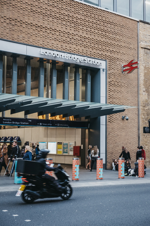 London, UK - March 16, 2019: People and motorbikes in front on London bridge rail station, the...
