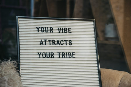 Your vibe attracts your tribe motivational quote on a white letter board.の写真素材