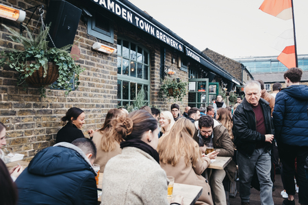 London, UK - March 23, 2019: People sitting at outdoor tables inside Camden Market, London. Started with 16 stalls in March 1974, Camden Market is one of the busiest retail destinations in London.のeditorial素材