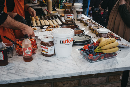 London, UK - March 23,2019: Staff cooking Dutch pancakes at a stall inside Camden Market, London. Started with 16 stalls in 1974, Camden Market is one of the busiest retail destinations in London.のeditorial素材
