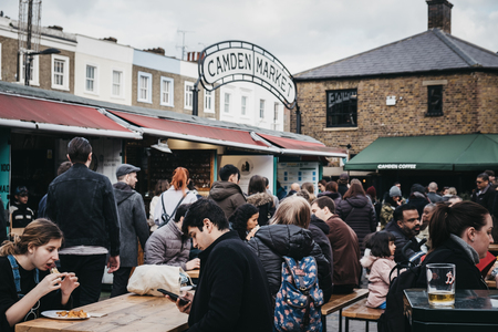 London, UK - March 23, 2019: People sitting at outdoor tables inside Camden Market, London. Started with 16 stalls in March 1974, Camden Market is one of the busiest retail destinations in London.のeditorial素材