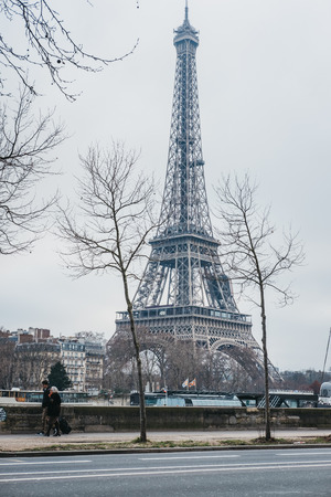 Paris, France - January 27, 2018: People walking along river Seine in Paris, Eiffel Tower on the background. Paris is one of the most visited cities in the world.のeditorial素材