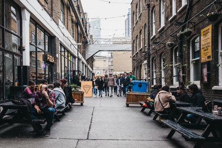 London, UK - April 6, 2019: People enjoying street food in Ely's Yard, a popular industrial-style street food market just off Brick Lane, East London.のeditorial素材