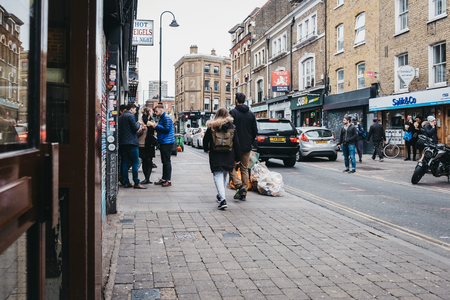 London, UK - April 6, 2019: People walking on Brick Lane, London. The street is the heart of the London's Bangladeshi-Sylheti community and is famous for its many curry houses.のeditorial素材