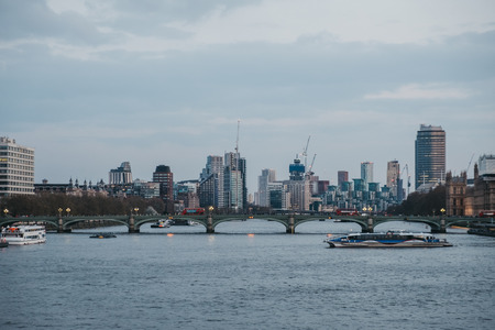 London, UK - April 13, 2019: Thames Clipper on River Thames, London skyline on the background, during blue hour. The Clippers are the fastest and most frequent fleet on the River Thames.のeditorial素材