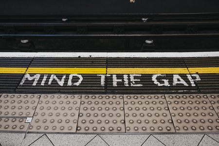 London, UK - April 13, 2019: Mind the gap sign an a platform of Embankment underground station. London Underground is the oldest underground railway in the world.のeditorial素材