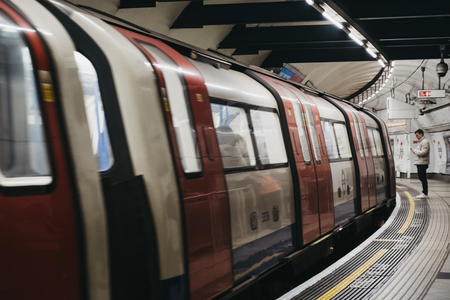 London, UK - April 13, 2019: Train arriving at London Underground station, motion blur. London Underground is the oldest underground railway in the world.のeditorial素材