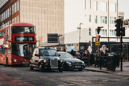 London, UK - April 13, 2019: Black cabs and a red double decker bus on Charing Cross Road, London, UK. Double decker bus is an iconic symbol of the city.のeditorial素材
