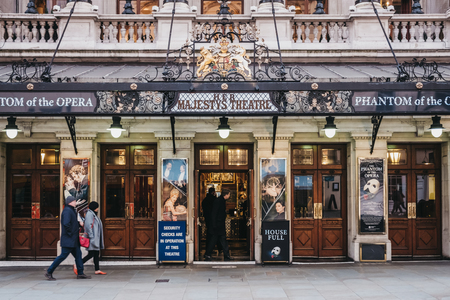 London, UK - April 13, 2019: People walking by Her Majesty Theatre, a theatre in West End of London whose name changes depending on the gender of the ruling monarch.のeditorial素材