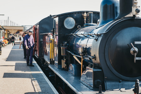 Sheringham, UK - April 21, 2019: Staff walking on platform next to The Poppy Line train, also known...