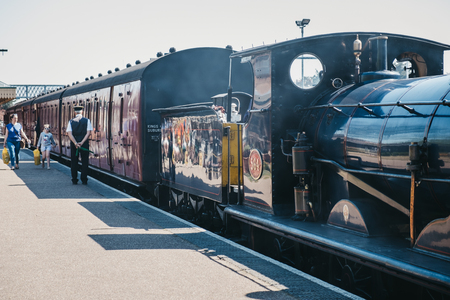 Sheringham, UK - April 21,2019: Staff waiting to signal departure of The Poppy Line train, also known as the North Norfolk Railway, a Heritage Steam Railway that runs from Sheringham to Holt,Nortfolk.のeditorial素材
