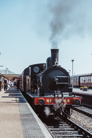 Sheringham, UK - April 21, 2019: Staff and passenger by The Poppy Line steam train, also known as the North Norfolk Railway, a Heritage Steam Railway that runs from Sheringham to Holt, Nortfolk.のeditorial素材