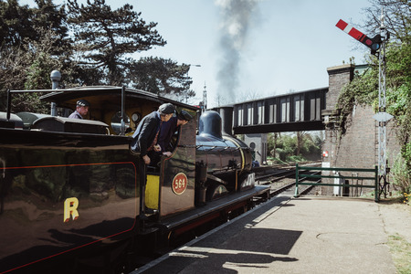 Sheringham, UK - April 21, 2019: Crew looking out the cab on The Poppy Line steam train, also known...