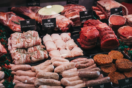 Elveden, UK - April 21, 2019: Variety of meats and meat products on sale inside The Courtyard, a country mall that sells gifts and locally produced food, and located just off A11 in Elveden, UK.のeditorial素材
