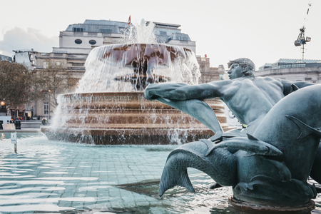 London, UK - April 14, 2019: Close up of a statue and fountain on Trafalgar Square, a public square in Charing Cross area of London that features some of Londonâs top attractions.のeditorial素材