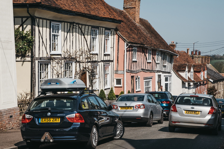 Lavenham, UK - April 19, 2019: Cars driving past half-timbered medieval cottages in Lavenham, a village in Suffolk, England, famous for its Guildhall, Little Hall and its architecture.のeditorial素材