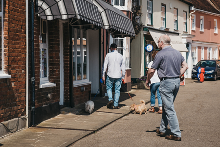 Lavenham, UK - April 19, 2019: People walking past the shops in Lavenham, a village in Suffolk, England, famous for its Guildhall, Little Hall and its architecture.のeditorial素材