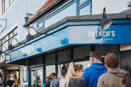 Wells-next-the-sea, UK - April 20, 2019: People queuing outside for take away from Frenchs, fish and chip shop in Wells-next-the-sea, a seaside town and port in Norfolk, UK, famous for its beach.のeditorial素材