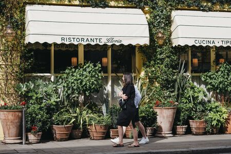 London, UK - June 15, 2019: People walking past Gloria, Italian restaurant in Shoreditch, London, famous for ivy-covered exterior walls and numerous plants in terracotta pots outside.のeditorial素材