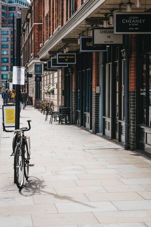 London, UK - June 15, 2019: Parked bicycle next to row of shops in Spitalfields Market, one of the finest surviving Victorian Market Halls in London with stalls offering fashion, antiques and food.のeditorial素材