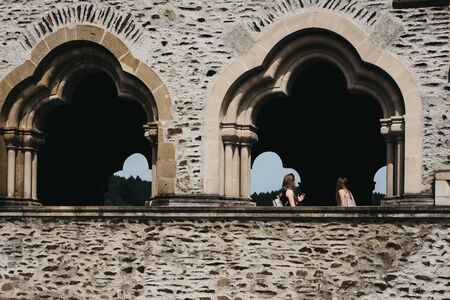Vianden, Luxembourg - May 18, 2019: People walking past the windows inside Vianden Castle,...