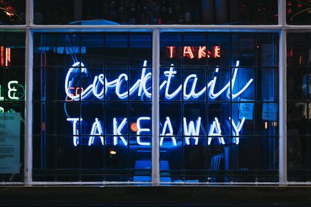 London, UK - June 5, 2019: Take Away Cocktails words in neon light signage on the window of a bar in Soho, an area of Central London famous for bars, cafes and restaurants.のeditorial素材