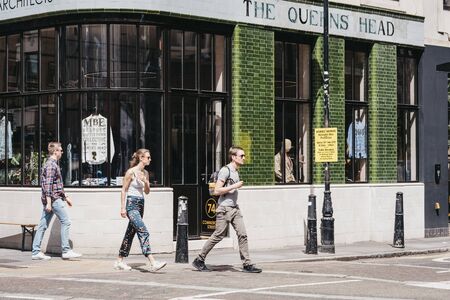 London, UK - June 22, 2019: People walking past Queens Head pub in Shoreditch, a trendy area of Londons East End that is home to an array of interesting markets, bars and restaurants.のeditorial素材