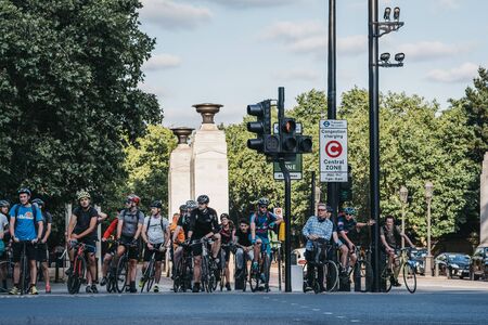 London, UK - July 15, 2019: Cyclists waiting on a red traffic light to cross a road in London, UK, in summer. Cycling is a popular way of getting around the city.のeditorial素材