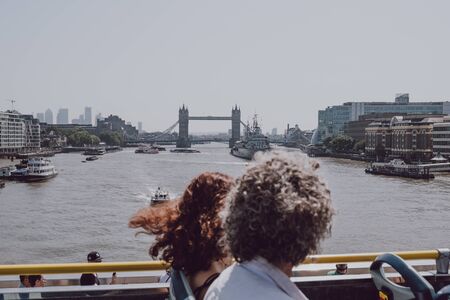 London, UK - July 29, 2019: Tourists enjoying views of London landmarks from top deck of tour bus on a summer day. Open top bus tours are amongst the most popular tourist activities in London.のeditorial素材
