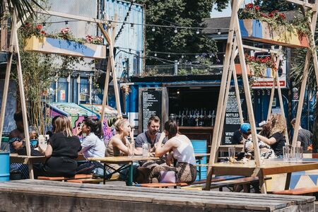 London, UK - July 16, 2019: People at the tables inside Pop Brixton, event venue and the home of a community of independent retailers, restaurants, street food startups and social enterprises.のeditorial素材