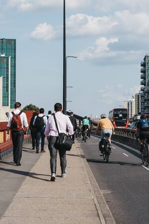 London, UK - July 16, 2019: Pedestrian and cyclists on Vauxhall Bridge in London, during rush hour, selective focus. Cycling is a popular way of getting around the city.のeditorial素材