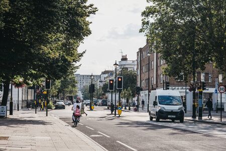 London, UK - July 16, 2019: Father and daughter cycling on a street in Pimlico on a bright summer day. Pimlico is an upscale residential area of London with quiet streets lined with stately homes.のeditorial素材