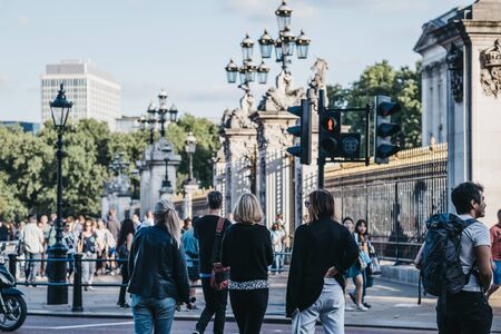 London, UK - July 15, 2019: People waiting to cross the road outside Buckingham Palace, the London residence and administrative headquarters of the monarch of the United Kingdom.のeditorial素材