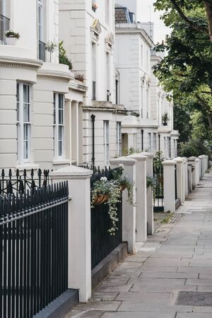 Row of white terraced houses on a street in London, UK, in summer.の写真素材