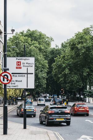 London, UK - July 18, 2019: Cars drive park directional road signs on a street in London, UK, motion blur, selective focus. London is one of the most traffic congested city in the world.のeditorial素材
