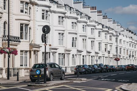 London, UK - July 18, 2019: Cars parked outside white terraced houses on a street in Paddington, an area of West London located between two parks, Notting Hill and the West End.のeditorial素材