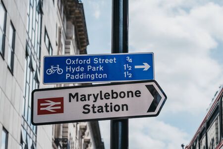 London, UK - July 18, 2019: Directional signs to Marylebone Station and cycling routes with distances to tourist attracting in London. Cycling is a popular way to get around the city.のeditorial素材