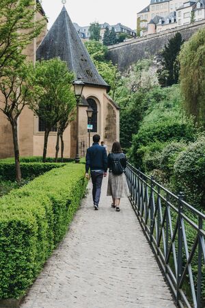 Luxembourg City, Luxembourg - May 19, 2019: Couple walking amongst greenery in Old Town in Luxembourg, the capital of the small European nation of the same name famed for its medieval fortifications.のeditorial素材