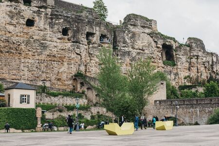 Luxembourg City,Luxembourg - May 19, 2019: People walking in Old Town of Luxembourg, Bock Casemates, a vast complex of underground tunnels & galleries used as WWII bomb shelters, on the background.のeditorial素材