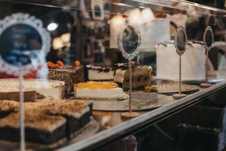 Cakes and desserts with on sale at a counter inside a cafe. Selective focus.の写真素材