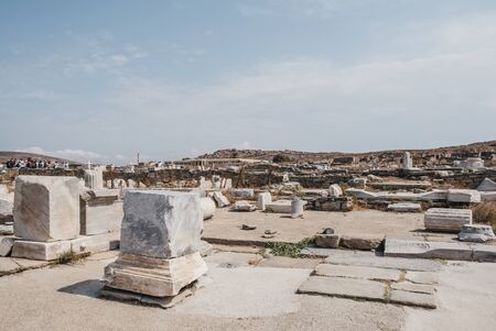 Delos, Greece - September 20, 2019: Ruins of agora on the island of Delos, Greece, an archaeological site near Mykonos in the Aegean Sea Cyclades archipelago, tour group and museum on the background.のeditorial素材