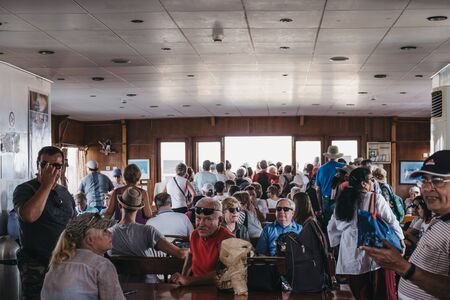 Delos, Greece- September 20, 2019: People waiting to disembark Delos Tours boat that has just arrived to to the island of Delos, a famous archaeological site near Mykonos. Selective focus.のeditorial素材