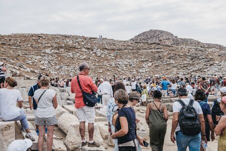 Delos, Greece - September 20, 2019: Large number of tourists watching performance at the ancient theatre on the Greek island of Delos, an archaeological site in the Aegean Sea. Selective focus.のeditorial素材