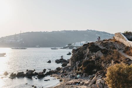 Mykonos, Greece - September 19, 2019: People walking on the path over the hill between Hidden and Platis Yialos beaches in Mykonos, a popular travel destination in Greece. Selective focus.のeditorial素材