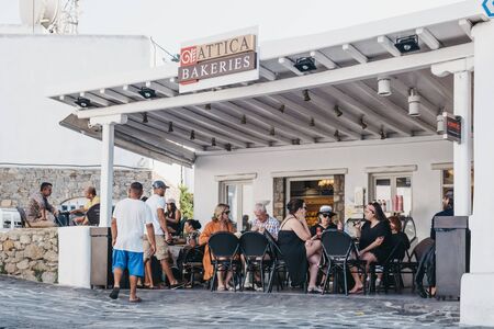 Mykonos Town, Greece - September 20, 2019: People sitting at Attica Bakery in Hora, also known as Mykonos Town, capital of the island and one of the best examples of Cycladic architecture.のeditorial素材