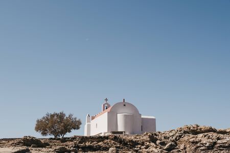 Low angle view of the church with red dome on a hill in Mykonos, Greece.の写真素材